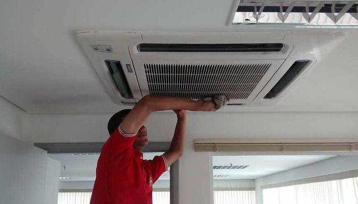 Homem trabalhando em um ar-condicionado central residencial