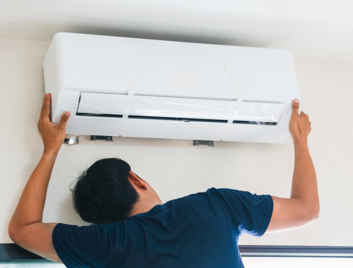 Foto de um homem instalando um ar-condicionado